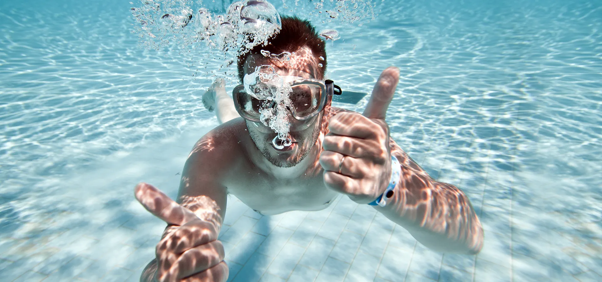 ein Mann mit Taucherbrille machte unter Wasser den Daumen nach oben