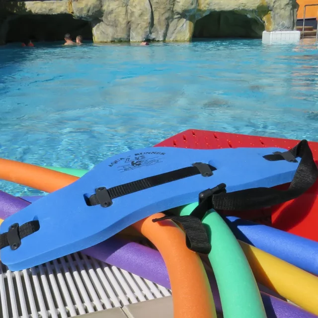 mehrer bunte Schwimmnudeln und zwei Schwimmgürtel liegen am Beckenrand