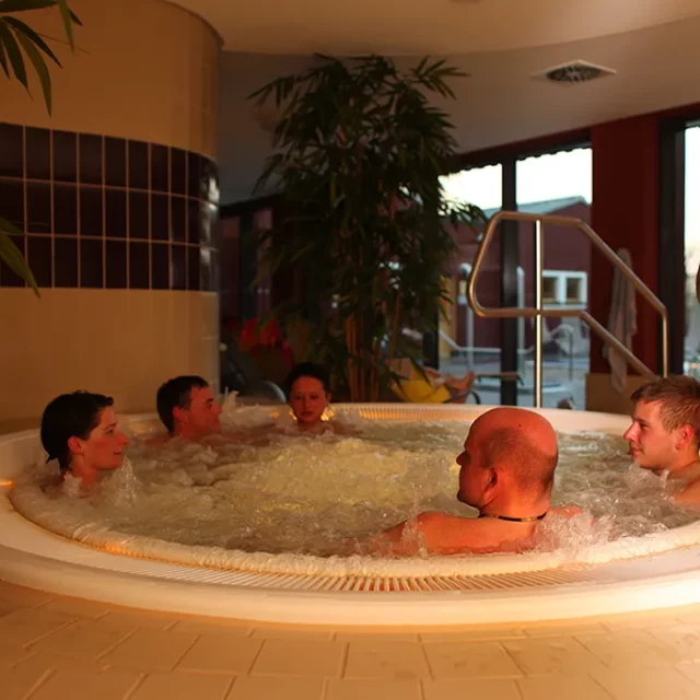 fünf Gäste entspannen im warmen Whirlpool